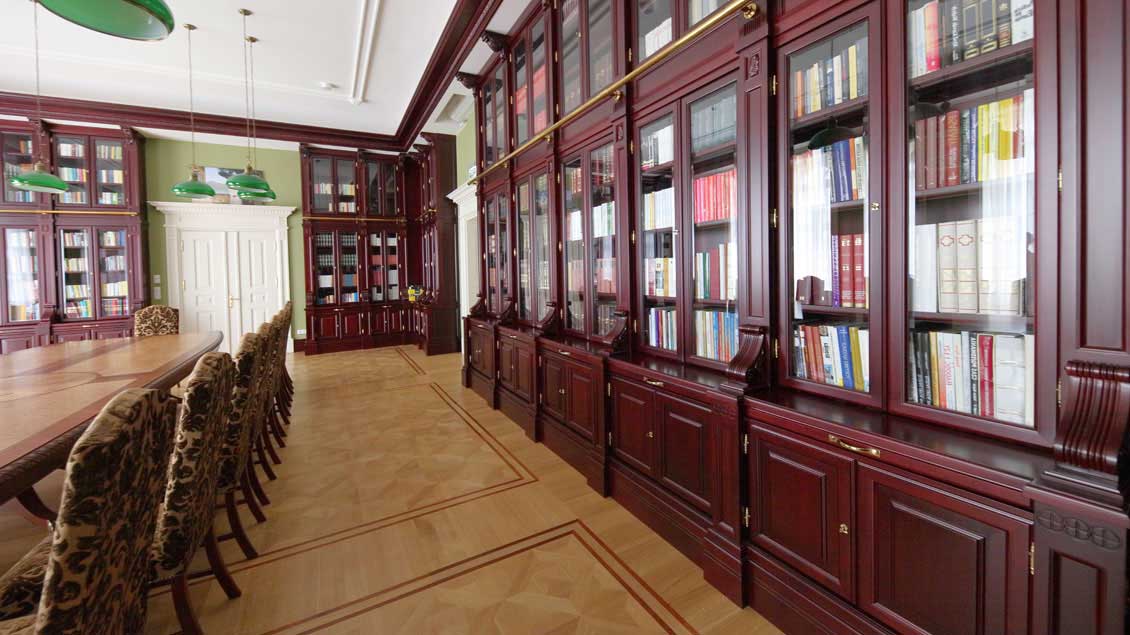 Ogromna drewniana biblioteczka (właściwie już biblioteka), zabudowa ściany od podłogi po sufit.
