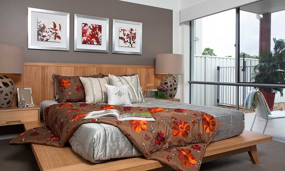 Drewniane łóżko hotelowe z drewnianymi, twardymi panelami ściennymi w roli zagłowia. Nad łóżkiem obrazy.